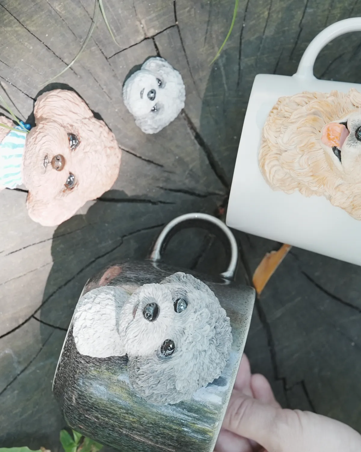 切り株の上に並べたマグカップとマグネットの作品一式